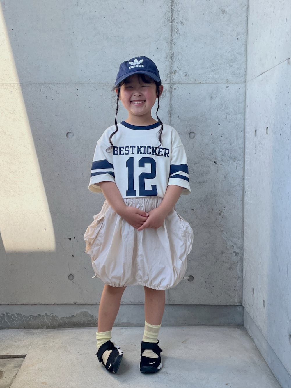 グリーン系のTシャツ/カットソー、ホワイト系のスカート、ブラック系のスニーカーを着用したキッズの夏コーディネートの2枚目の写真