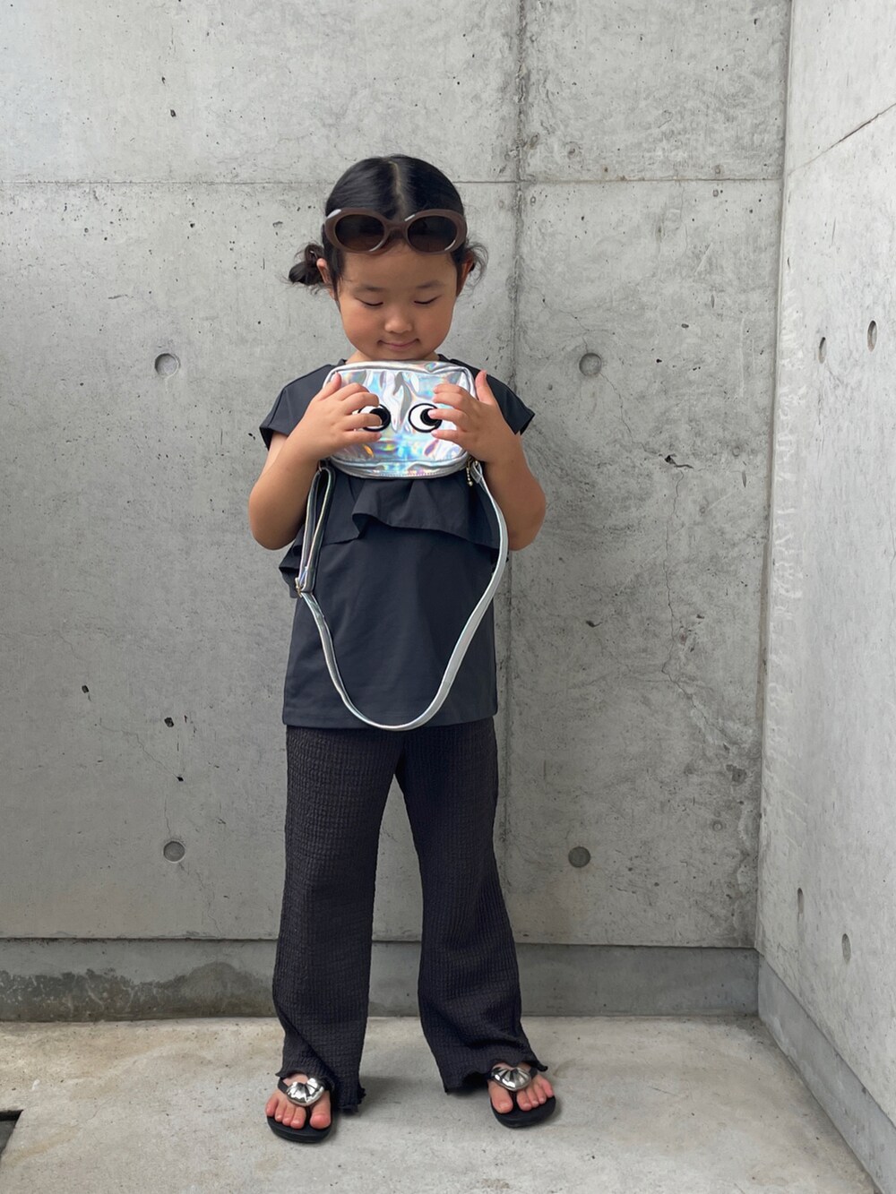 グレー系のタンクトップ、シルバー系のショルダーバッグ、グレー系のその他パンツを着用したキッズの夏コーディネートの4枚目の写真