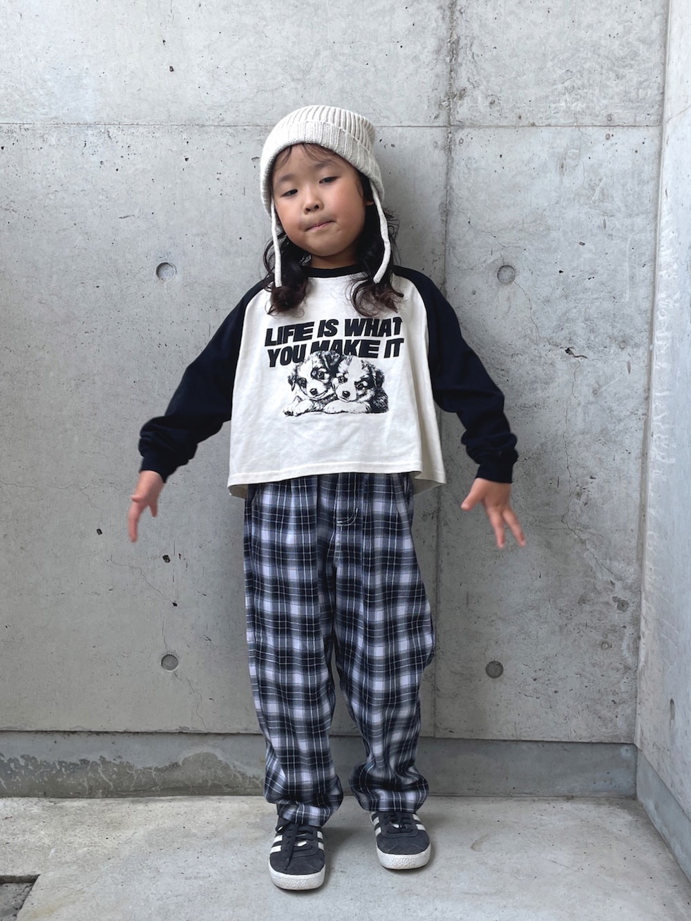 ブラック系のスニーカー、ブラック系のパンツ、ホワイト系のトップスを着用したキッズの秋コーディネートの5枚目の写真