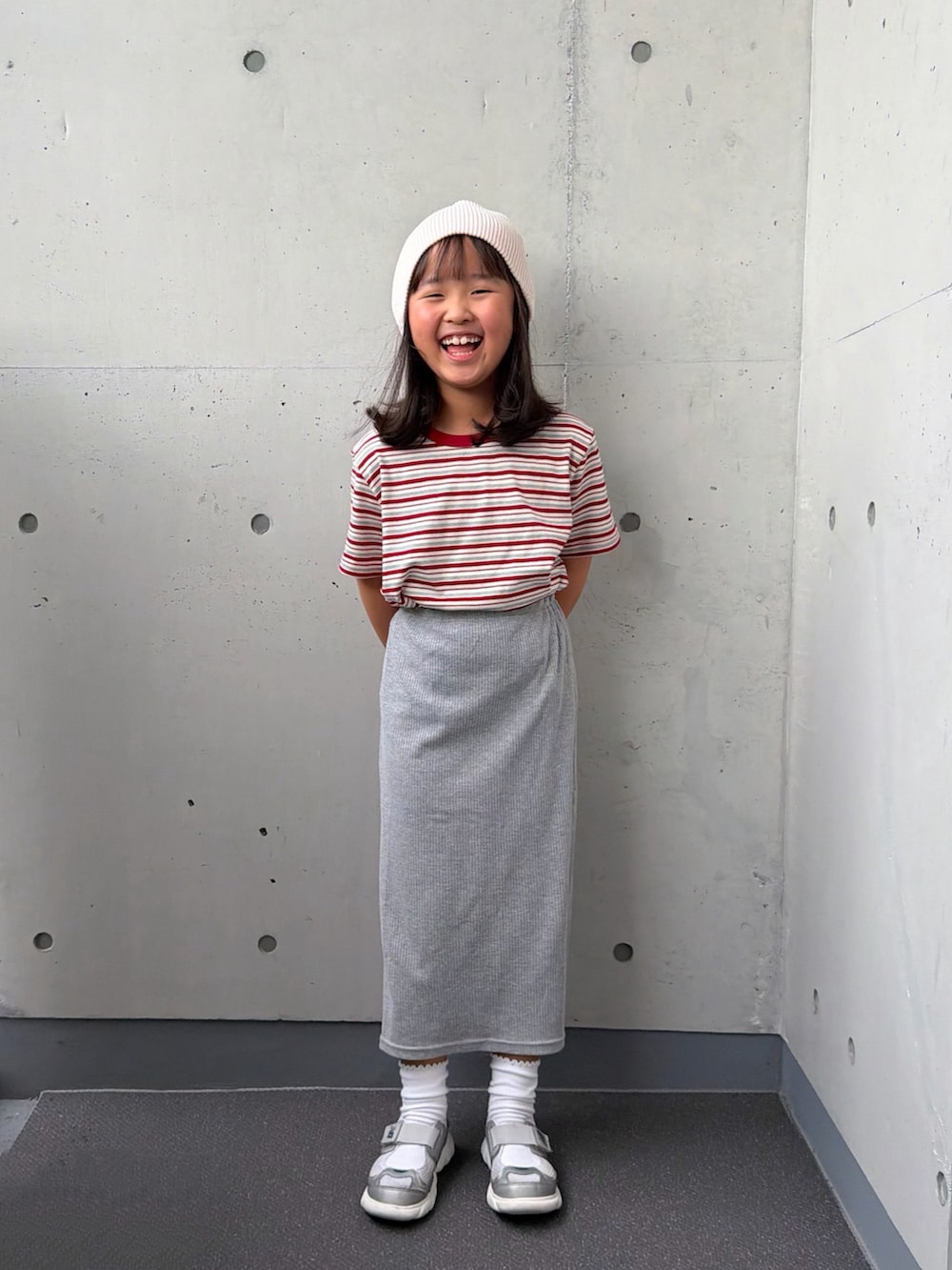 ホワイト系のTシャツ/カットソー、グレー系のスカート、シルバー系のスニーカーを着用したキッズの秋コーディネートの5枚目の写真