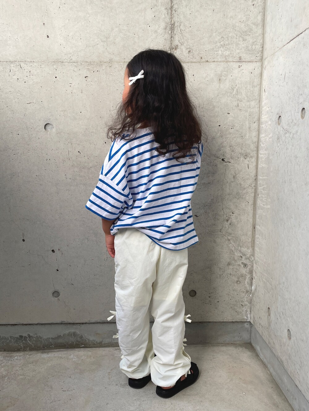 ブルー系のTシャツ/カットソー、ホワイト系のその他パンツ、ブラック系のサンダルを着用したキッズの春コーディネートの4枚目の写真