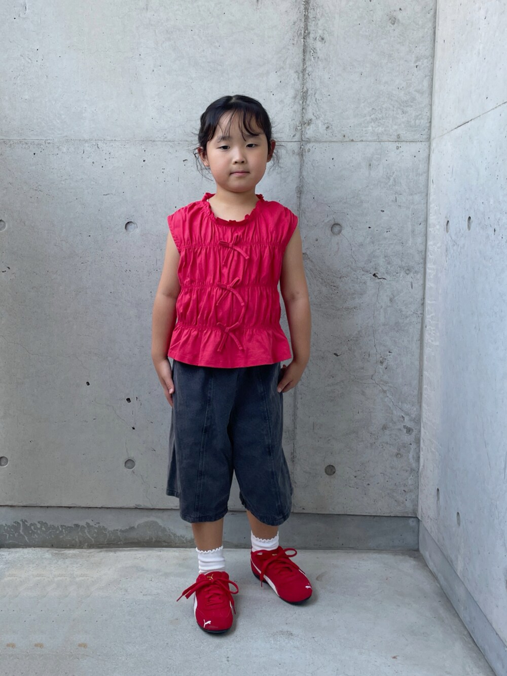 ブラック系のデニムパンツ、レッド系のスニーカー、レッド系のトップスを着用したキッズの夏コーディネートの5枚目の写真