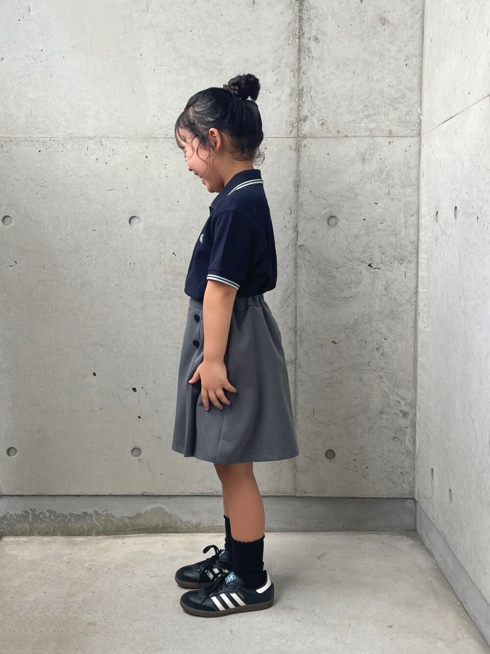 ブラック系のスニーカー、ブルー系のポロシャツ、ブラウン系のショルダーバッグを着用したキッズの秋コーディネートの4枚目の写真