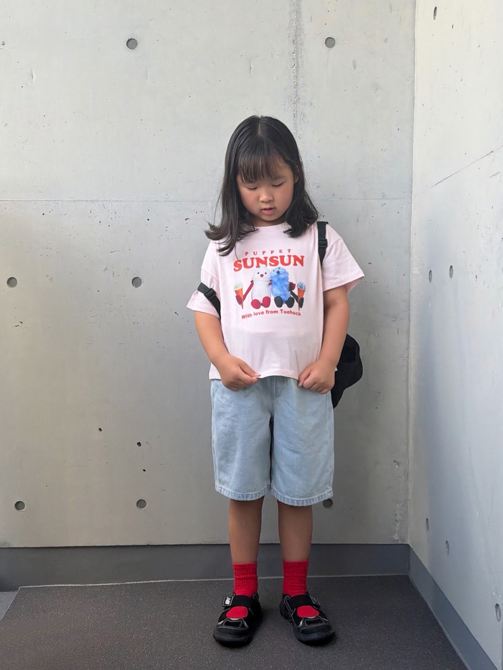 ブラック系のサンダル、ブラック系のバックパック/リュック、ピンク系のTシャツ/カットソーを着用したキッズの秋コーディネートの4枚目の写真