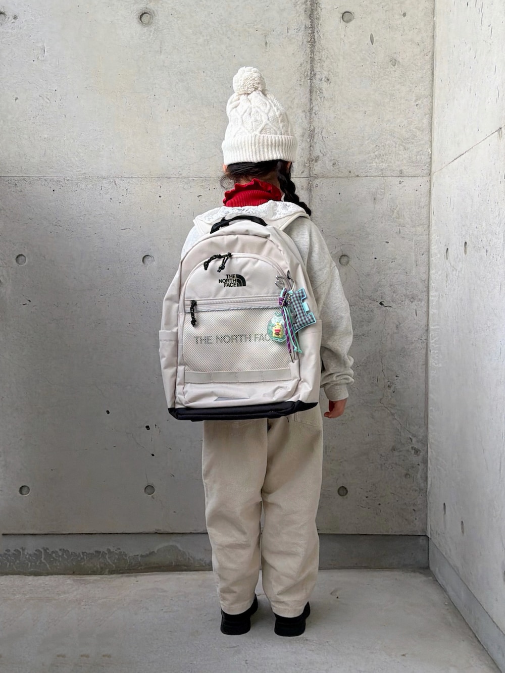 ベージュ系のスウェット、レッド系のニット/セーター、ベージュ系のその他パンツを着用したキッズの冬コーディネートの4枚目の写真