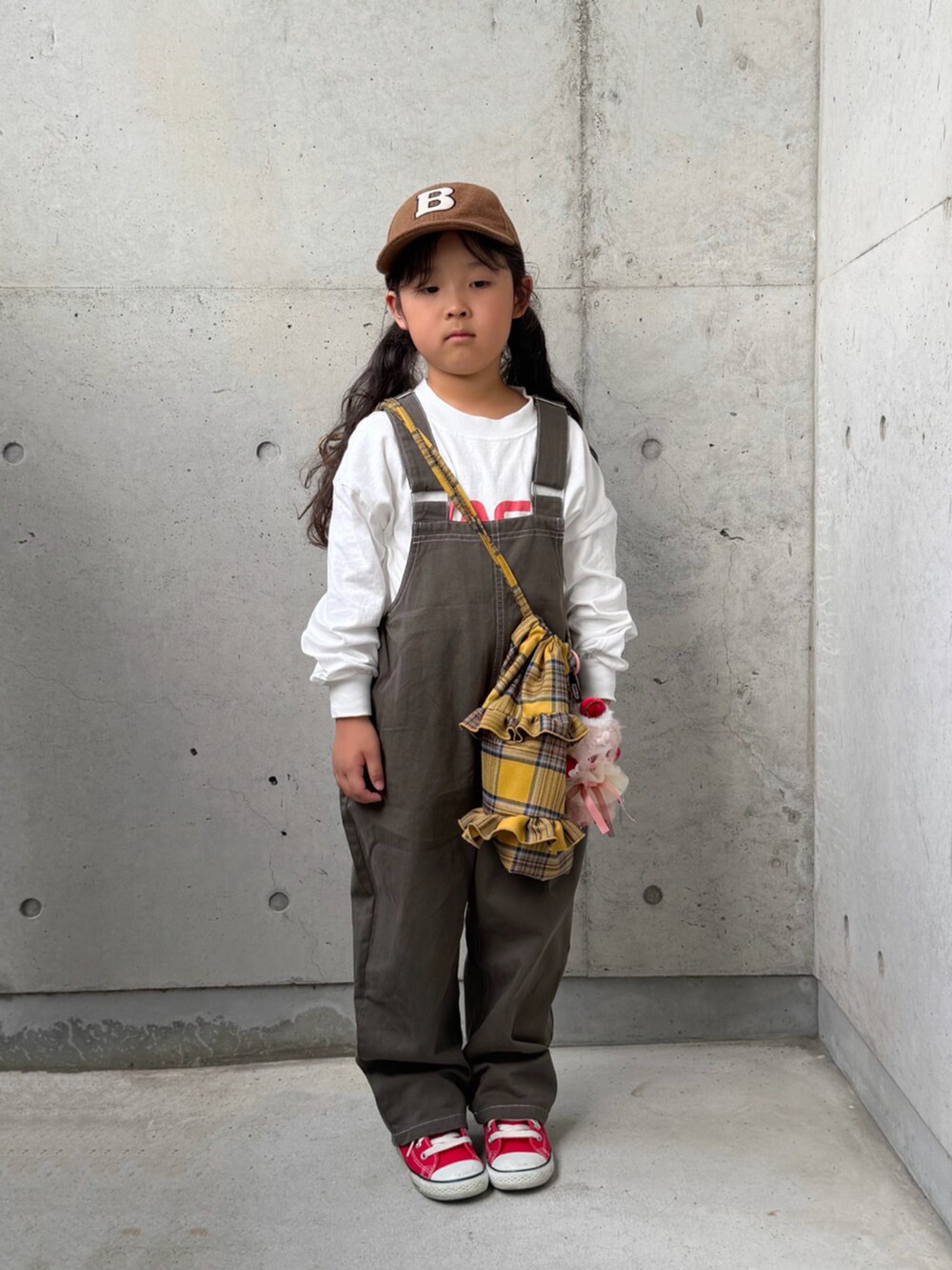 レッド系のスニーカー、グレー系のサロペット/オーバーオール、イエロー系のバックパック/リュックを着用したキッズの秋コーディネートの4枚目の写真