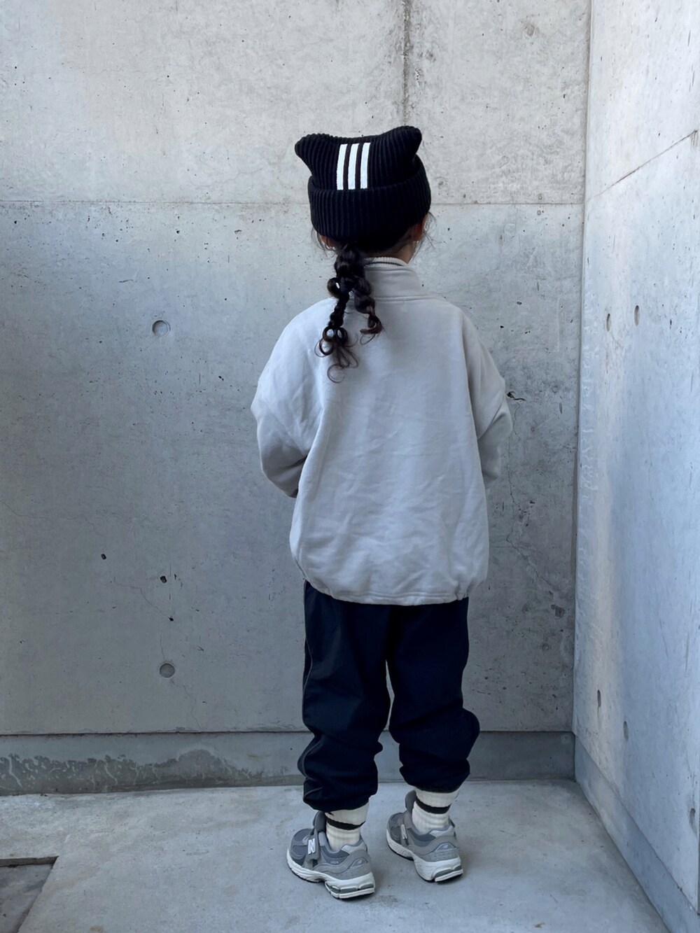 ブラック系のパンツ、ホワイト系のトップス、グレー系のスウェットを着用したキッズの冬コーディネートの3枚目の写真