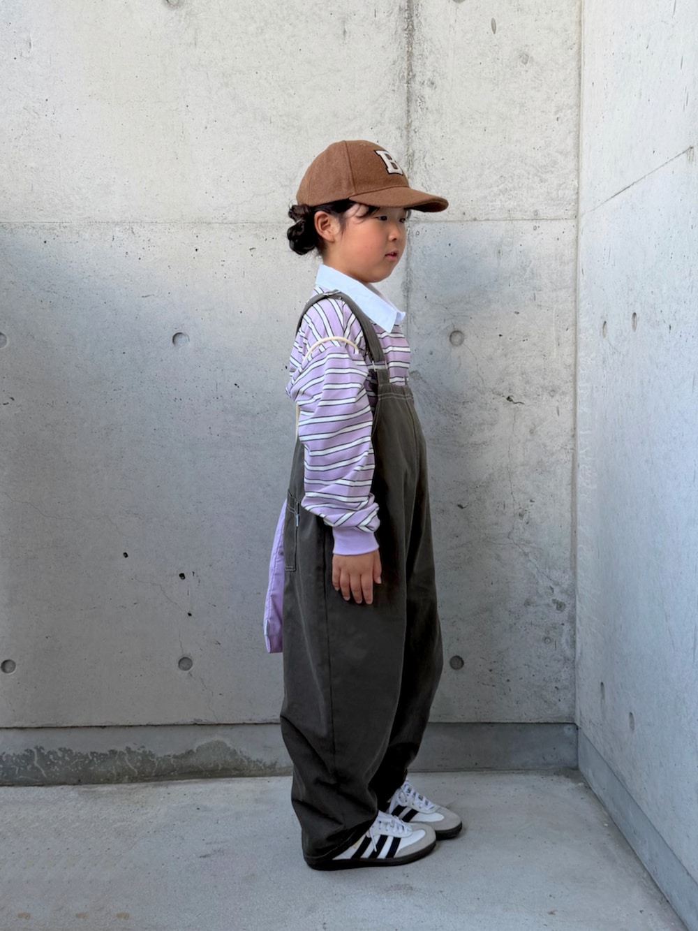 パープル系のポロシャツ、グレー系のサロペット/オーバーオール、パープル系のエコバッグ/サブバッグを着用したキッズの秋コーディネートの4枚目の写真