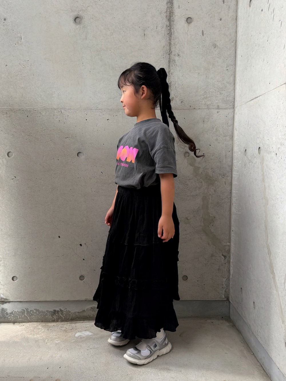 ブラック系のスカート、シルバー系のスニーカー、グレー系のTシャツ/カットソーを着用したキッズの夏コーディネートの3枚目の写真