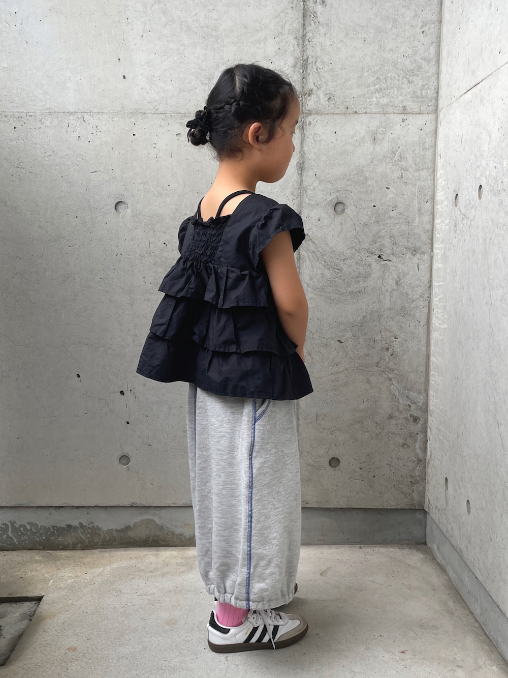 ホワイト系のスニーカー、グレー系のスカート、ブラック系のシャツ/ブラウスを着用したキッズの秋コーディネートの2枚目の写真