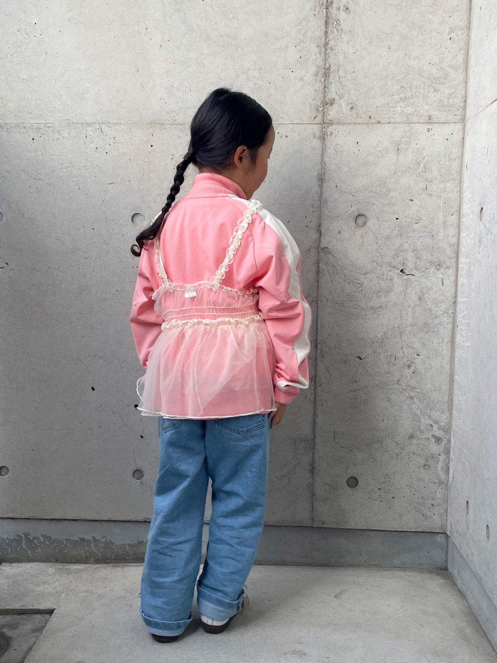 ピンク系のジャージ、ブラック系のTシャツ/カットソー、ホワイト系のスニーカーを着用したキッズの春コーディネートの3枚目の写真