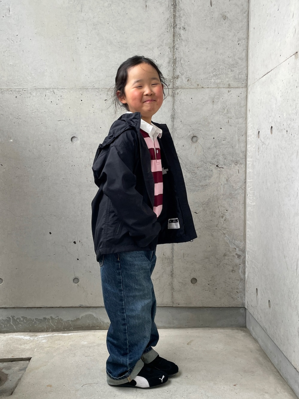 ブルー系のデニムパンツ、ブラック系のマウンテンパーカー、ピンク系のTシャツ/カットソーを着用したキッズの春コーディネートの3枚目の写真