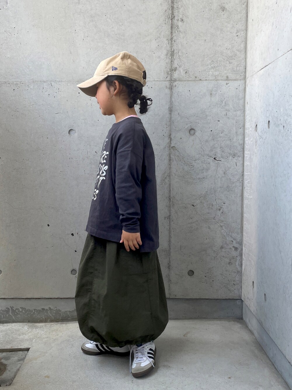 ホワイト系のスニーカー、グリーン系のスカート、グレー系のTシャツ/カットソーを着用したキッズの春コーディネートの2枚目の写真