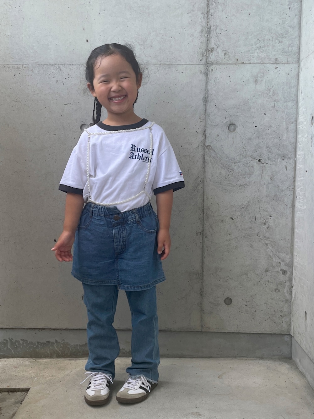 ホワイト系のTシャツ/カットソー、ブルー系のデニムパンツ、ホワイト系のスニーカーを着用したキッズの秋コーディネートの5枚目の写真