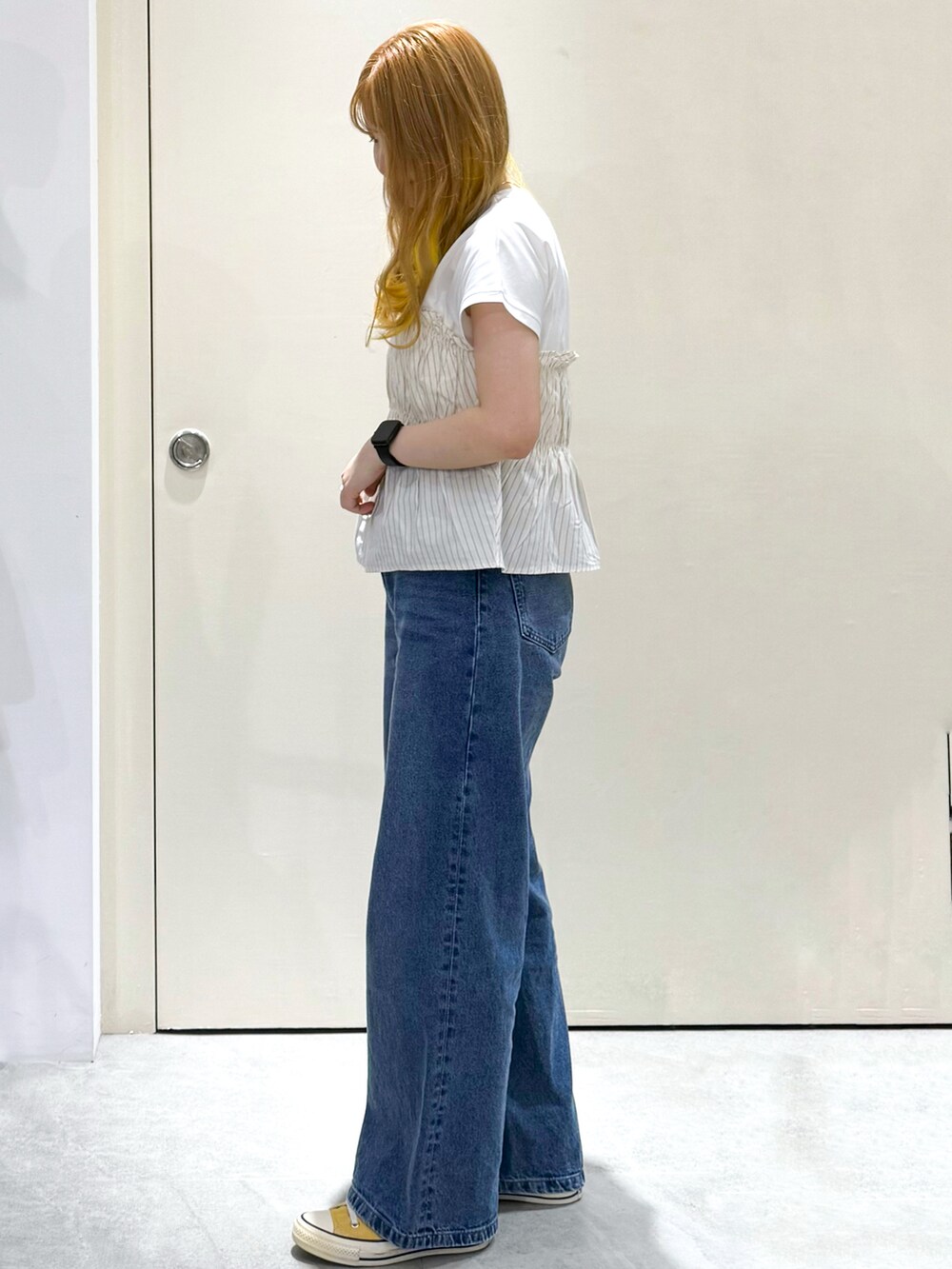 ブルー系のデニムパンツ、シルバー系のトートバッグ、ベージュ系のTシャツ/カットソーを着用したレディースの春コーディネートの3枚目の写真