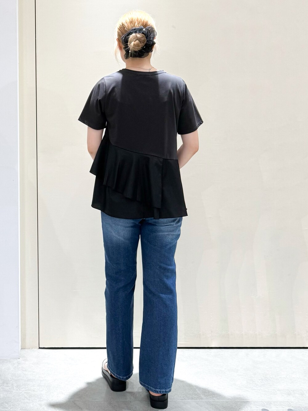 ブラック系のTシャツ/カットソー、ブルー系のデニムパンツ、ホワイト系のサンダルを着用したレディースの夏コーディネートの4枚目の写真