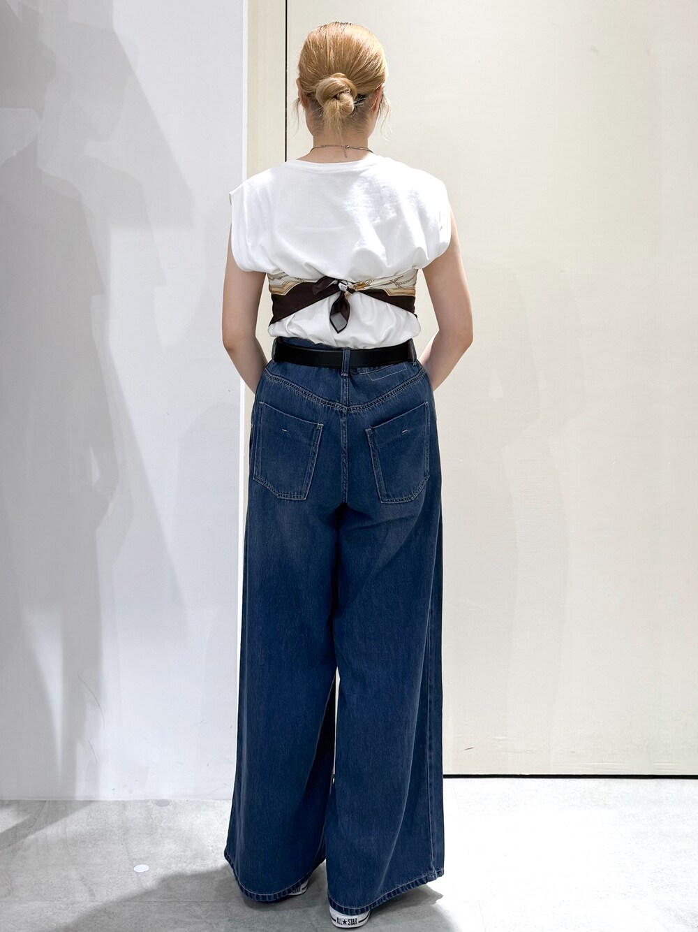 ホワイト系のTシャツ/カットソー、ブルー系のデニムパンツ、イエロー系のボストンバッグを着用したレディースの夏コーディネートの3枚目の写真