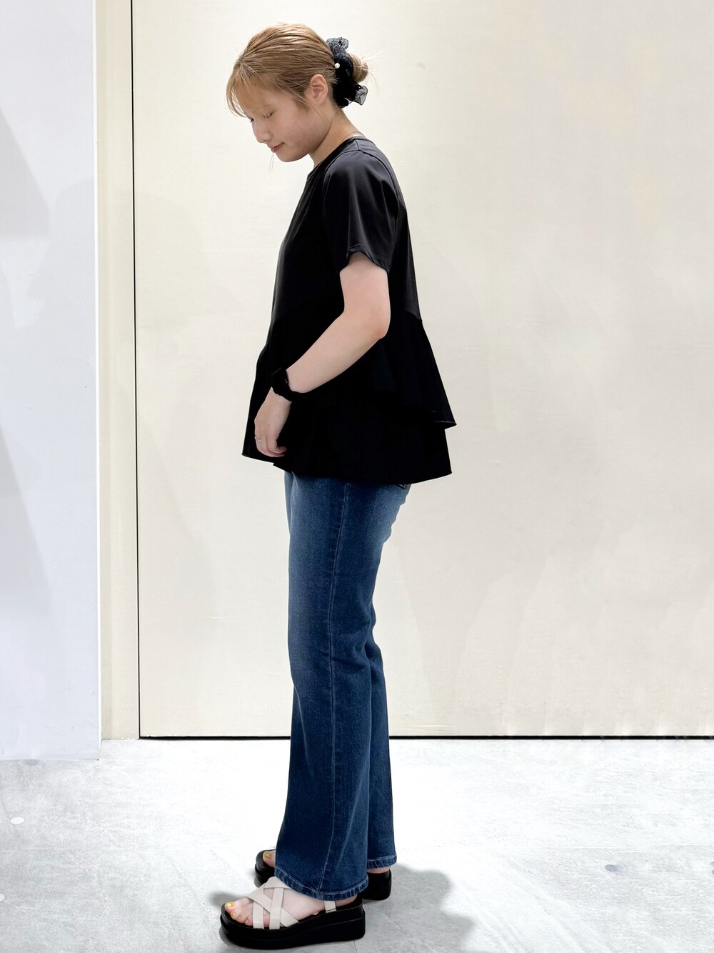 ブラック系のTシャツ/カットソー、ブルー系のデニムパンツ、ホワイト系のサンダルを着用したレディースの夏コーディネートの3枚目の写真