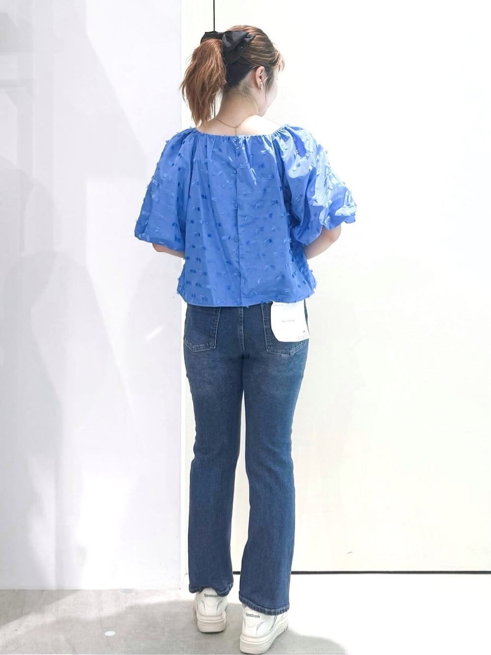 ブルー系のシャツ/ブラウス、ブルー系のデニムパンツ、シルバー系のショルダーバッグを着用したレディースの夏コーディネートの5枚目の写真