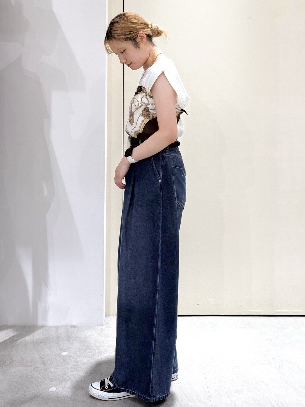 ホワイト系のTシャツ/カットソー、ブルー系のデニムパンツ、イエロー系のボストンバッグを着用したレディースの夏コーディネートの2枚目の写真