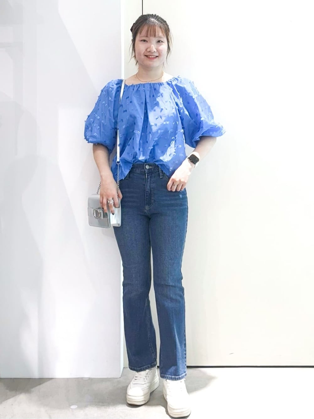 ブルー系のシャツ/ブラウス、ブルー系のデニムパンツ、シルバー系のショルダーバッグを着用したレディースの夏コーディネートの2枚目の写真