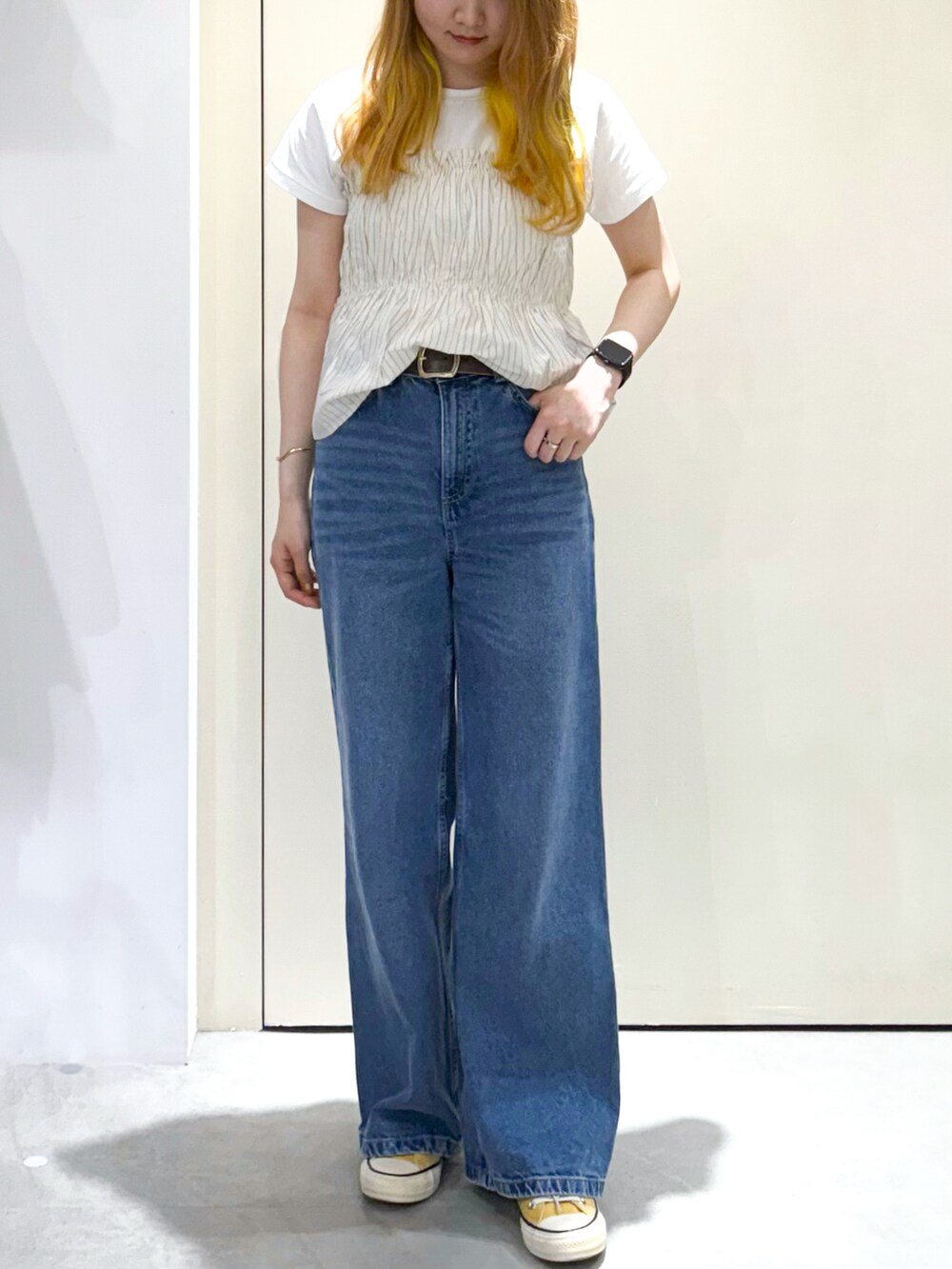 ブルー系のデニムパンツ、シルバー系のトートバッグ、ベージュ系のTシャツ/カットソーを着用したレディースの春コーディネートの8枚目の写真