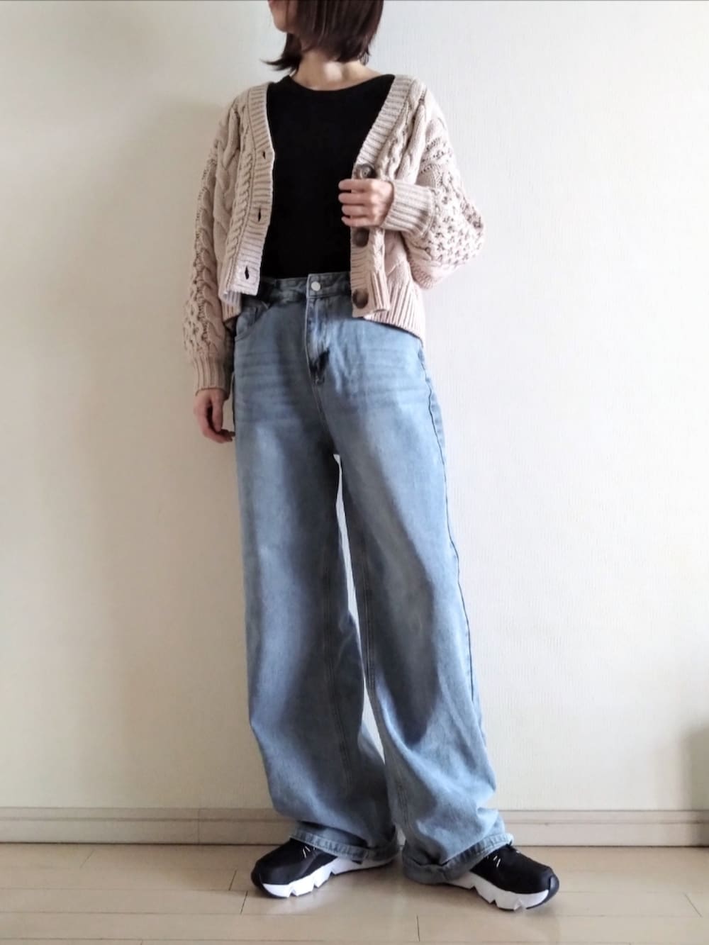 ブラウン系のカーディガン/ボレロ、ブラック系のTシャツ/カットソー、ブルー系のデニムパンツを着用したレディースの秋コーディネートの2枚目の写真