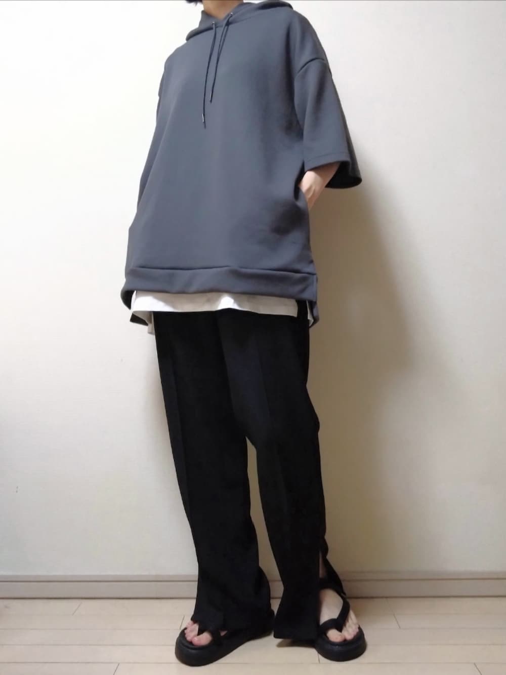 グレー系のパーカー、ブラック系のパンツ、ブラック系のサンダルを着用したレディースの夏コーディネートの2枚目の写真