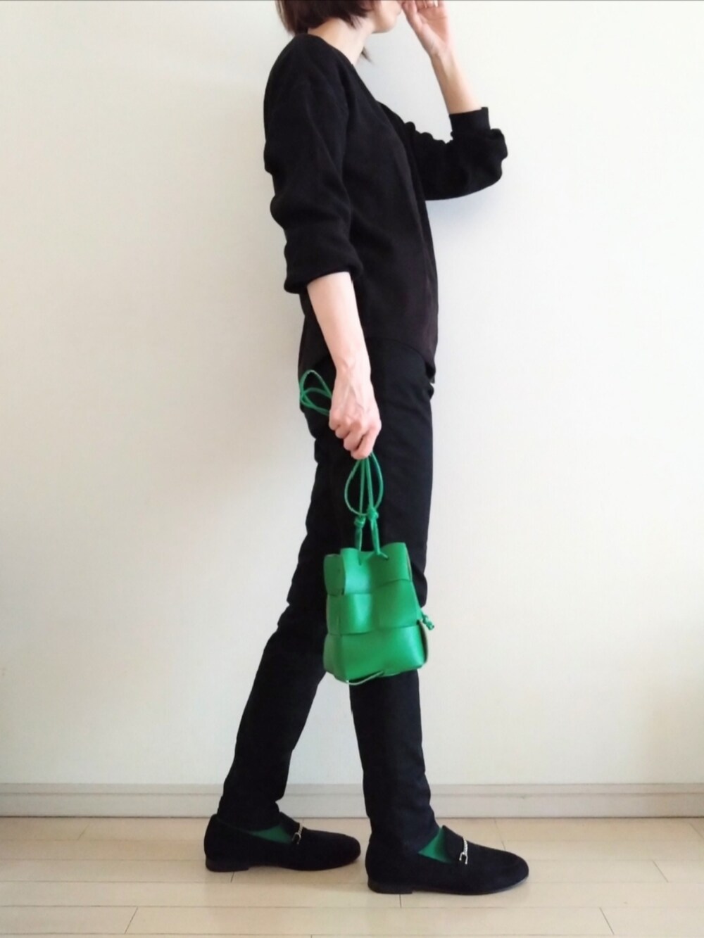 ブラック系のTシャツ/カットソー、ブラック系のパンツ、グリーン系のショルダーバッグを着用したレディースの秋コーディネートの2枚目の写真
