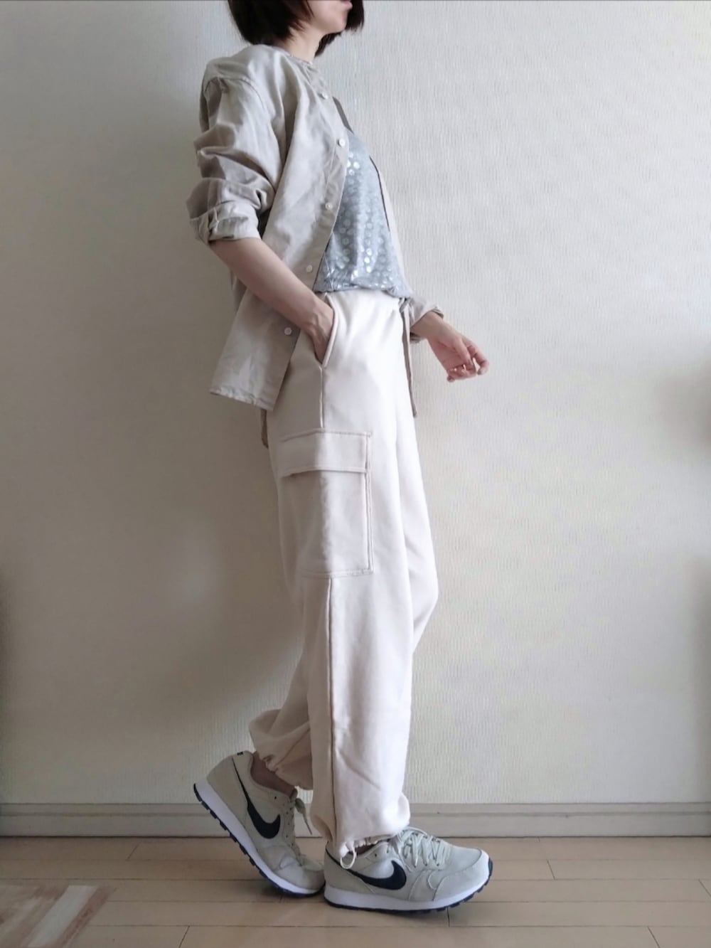 シルバー系のTシャツ/カットソー、ベージュ系のシャツ/ブラウス、ホワイト系のカーゴパンツを着用したレディースの春コーディネートの2枚目の写真