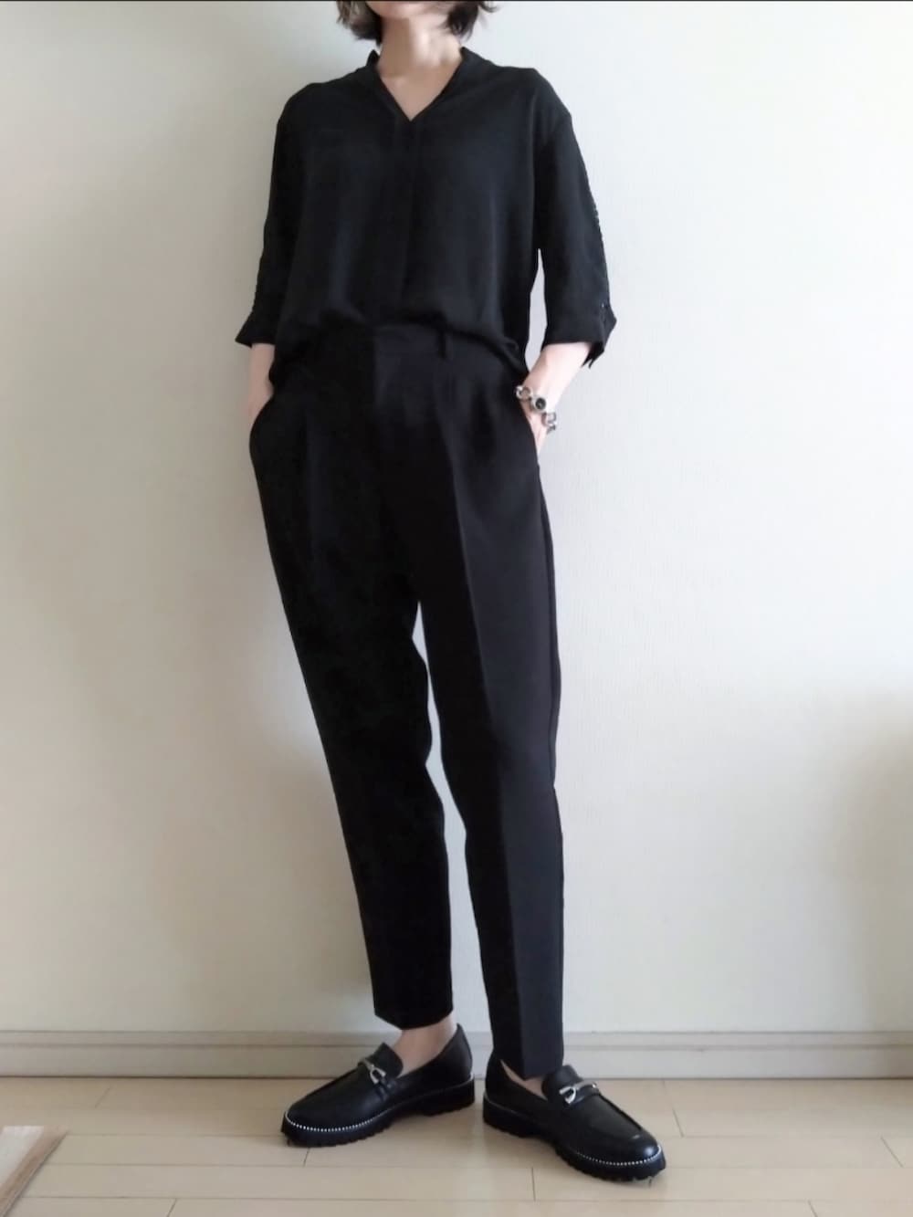 ブラック系のシャツ/ブラウス、ブラック系のスラックス、ブラック系のトートバッグを着用したレディースの夏コーディネートの2枚目の写真