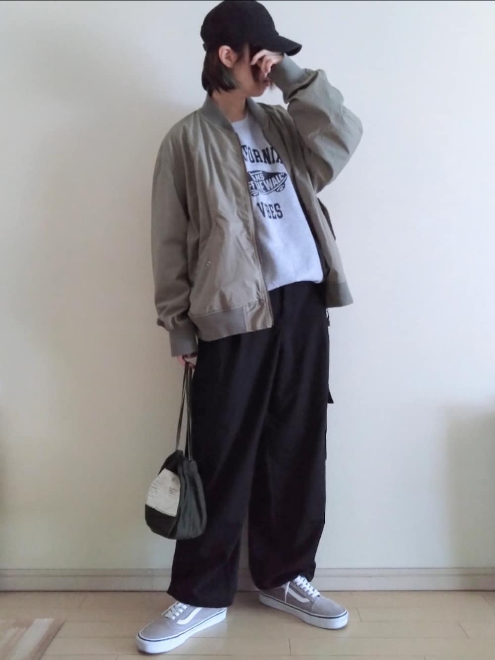 グリーン系のMA-1、グレー系のスウェット、ブラック系のカーゴパンツを着用したレディースの春コーディネートの2枚目の写真