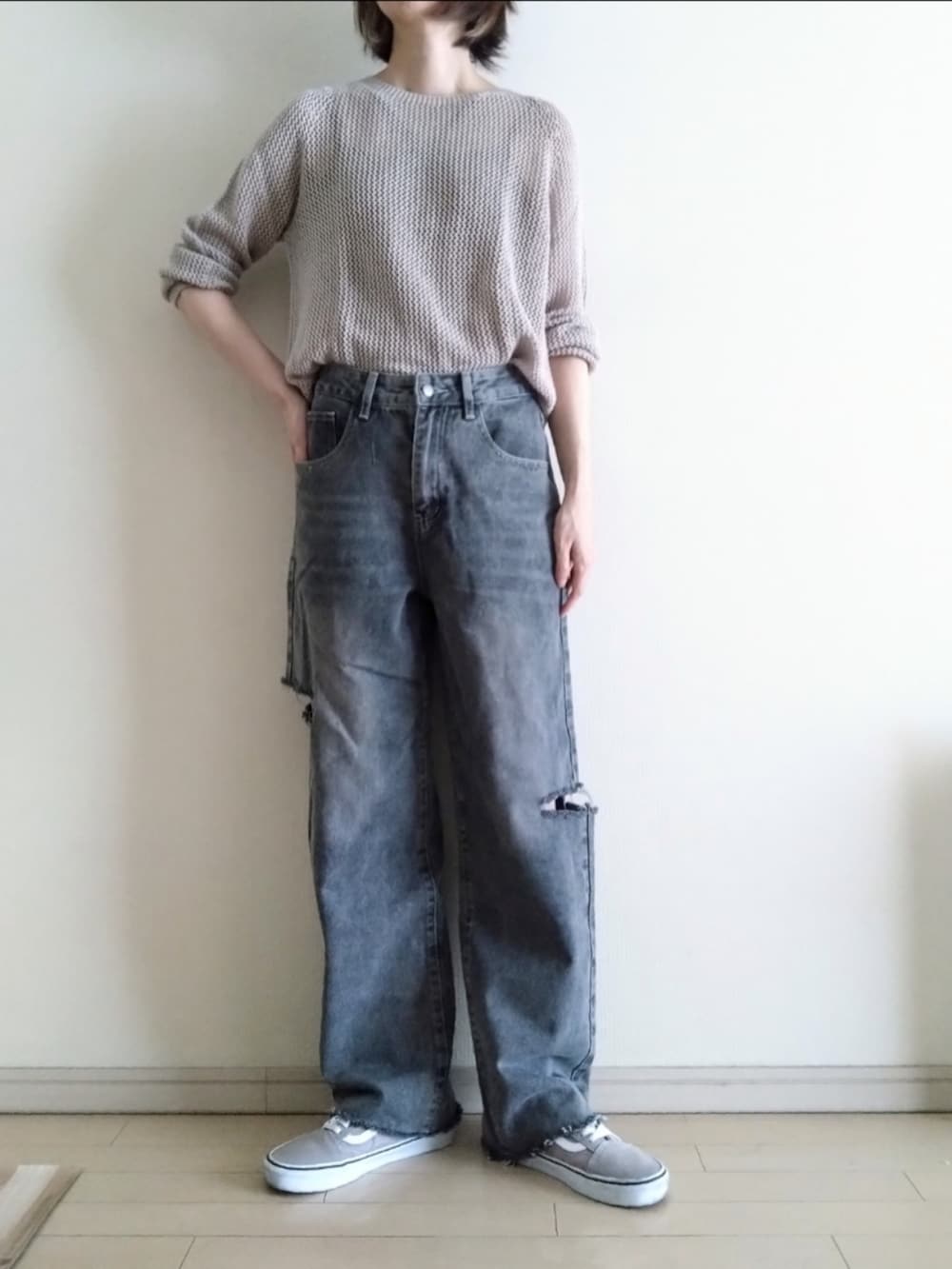 グレー系のニット/セーター、ブラック系のキャミソール、グレー系のデニムパンツを着用したレディースの春コーディネートの2枚目の写真