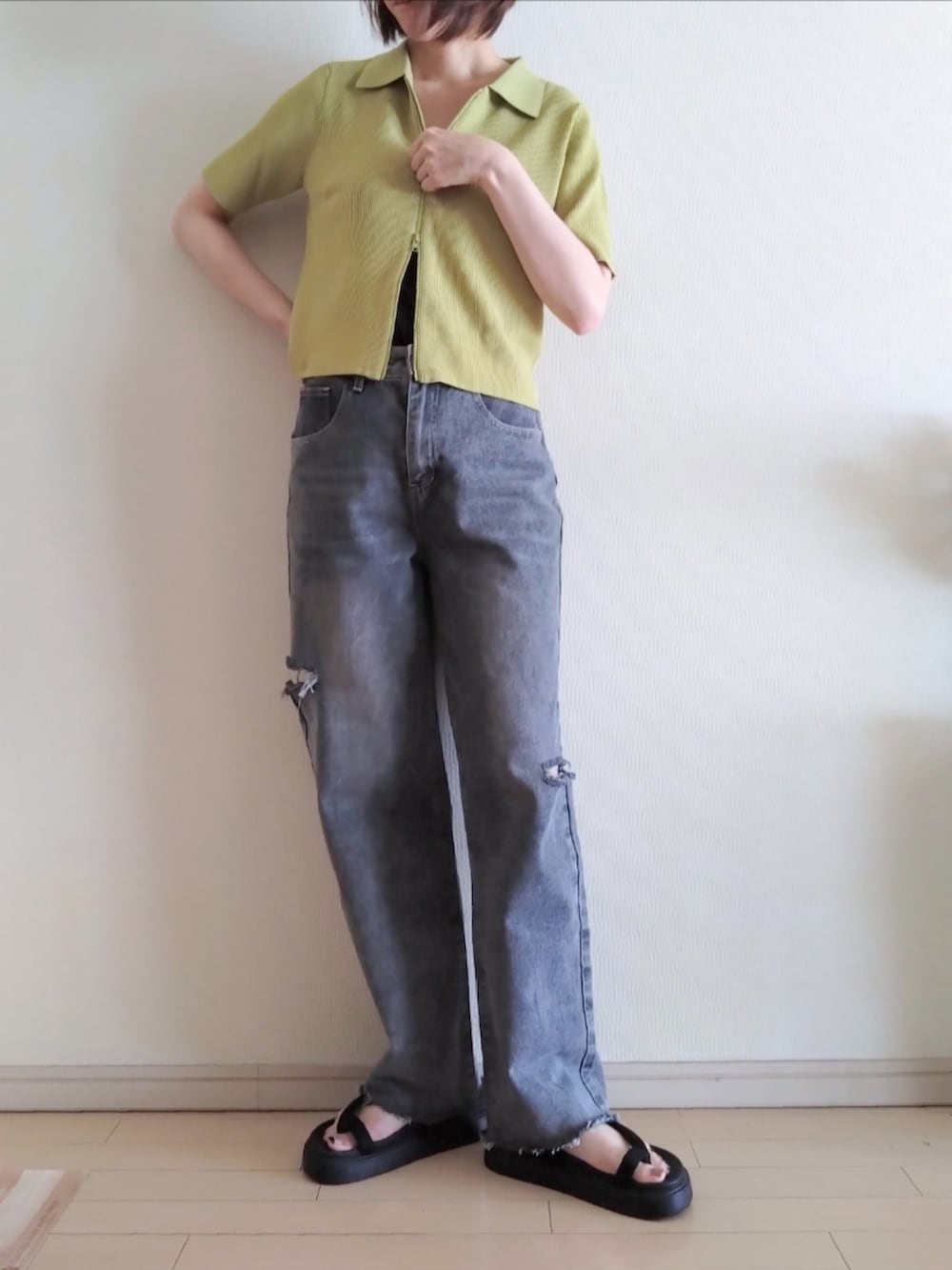 イエロー系のカーディガン/ボレロ、ブラック系のキャミソール、グレー系のデニムパンツを着用したレディースの春コーディネートの3枚目の写真