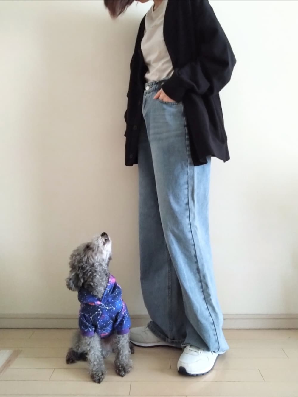 ブラック系のカーディガン/ボレロ、ベージュ系のTシャツ/カットソー、ブルー系のデニムパンツを着用したレディースの春コーディネートの2枚目の写真