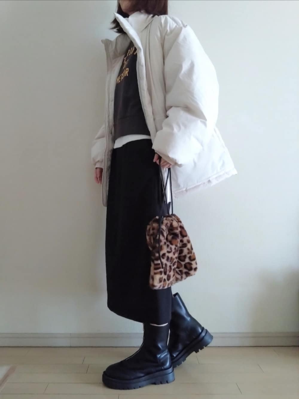 ホワイト系のダウンジャケット/コート、ブラック系のスウェット、ブラック系のスカートを着用したレディースの冬コーディネートの2枚目の写真