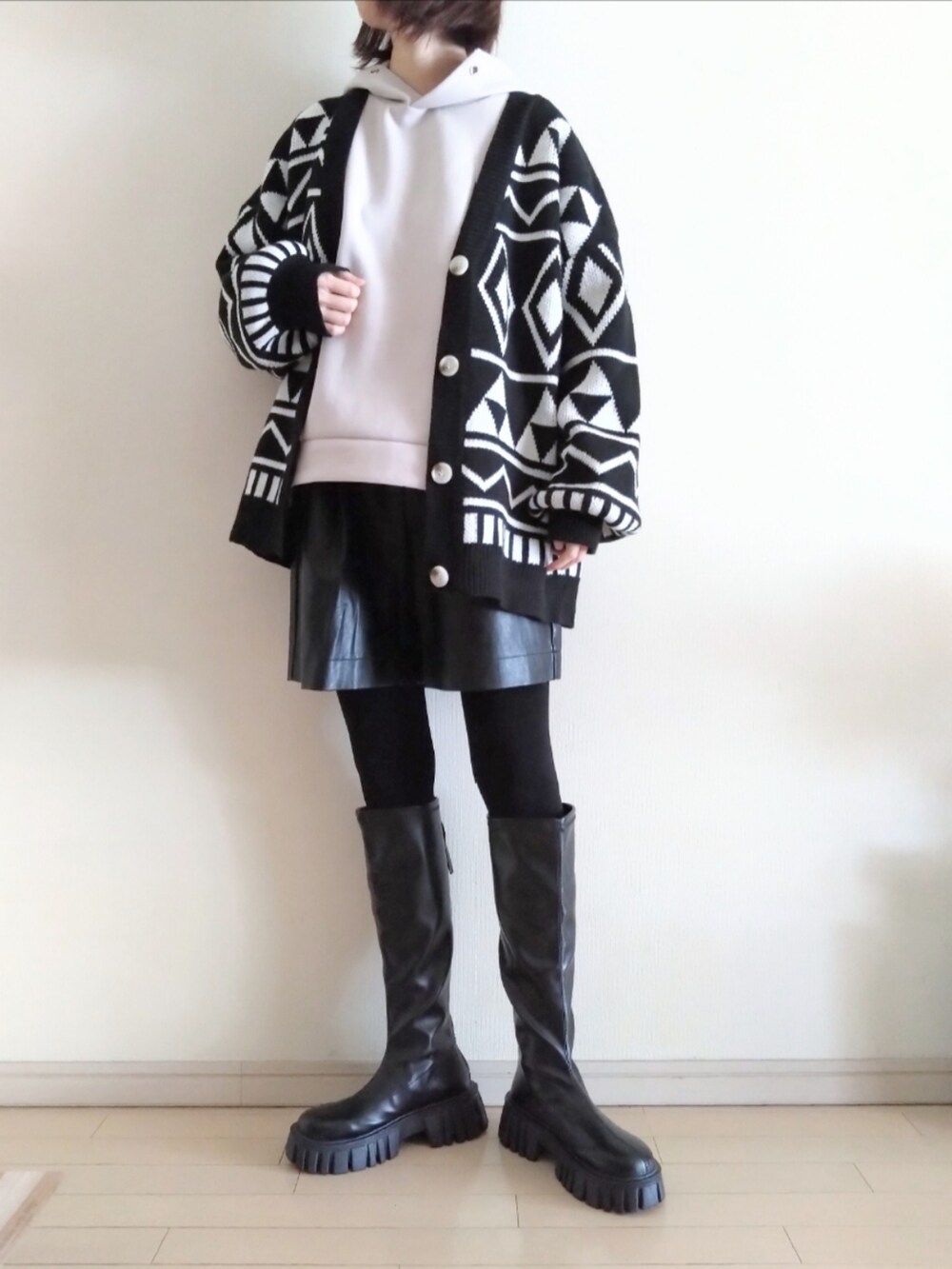 ベージュ系のパーカー、ブラック系のカーディガン/ボレロ、ブラック系のその他パンツを着用したレディースの春コーディネートの2枚目の写真