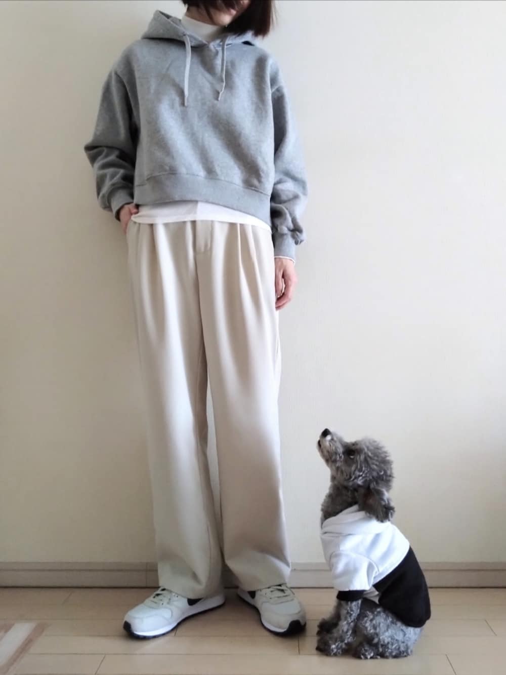 ベージュ系のステンカラーコート、グレー系のパーカー、ホワイト系のTシャツ/カットソーを着用したレディースの冬コーディネートの3枚目の写真