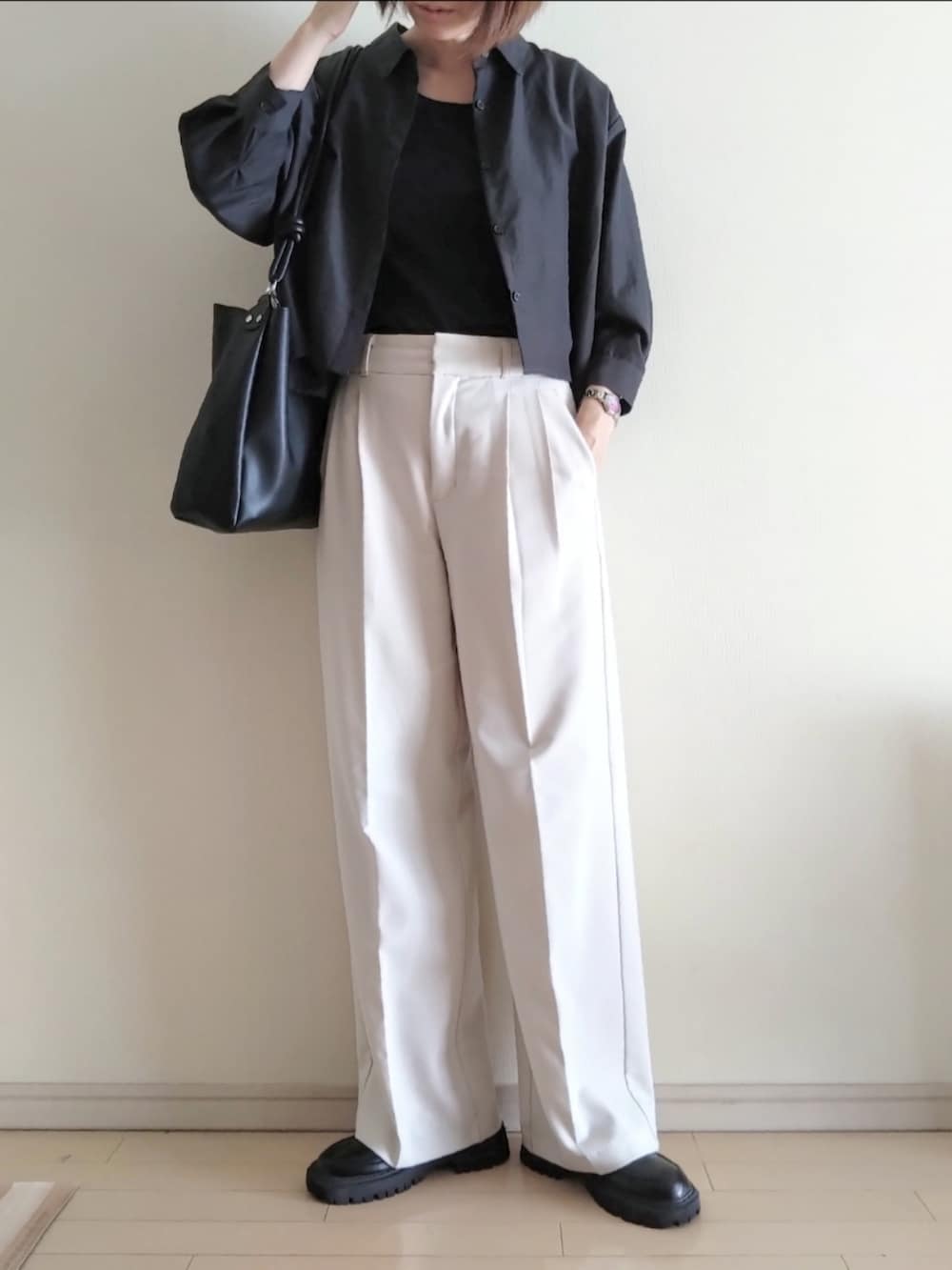 グレー系のシャツ/ブラウス、ブラック系のタンクトップ、ホワイト系のスラックスを着用したレディースの秋コーディネートの2枚目の写真