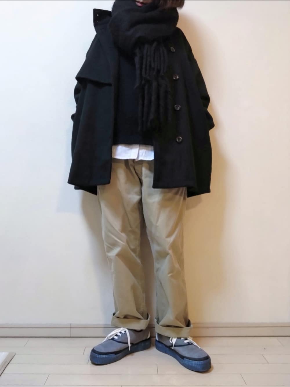 ブラック系のステンカラーコート、ブラック系のニット/セーター、グレー系のシャツ/ブラウスを着用したレディースの冬コーディネートの2枚目の写真