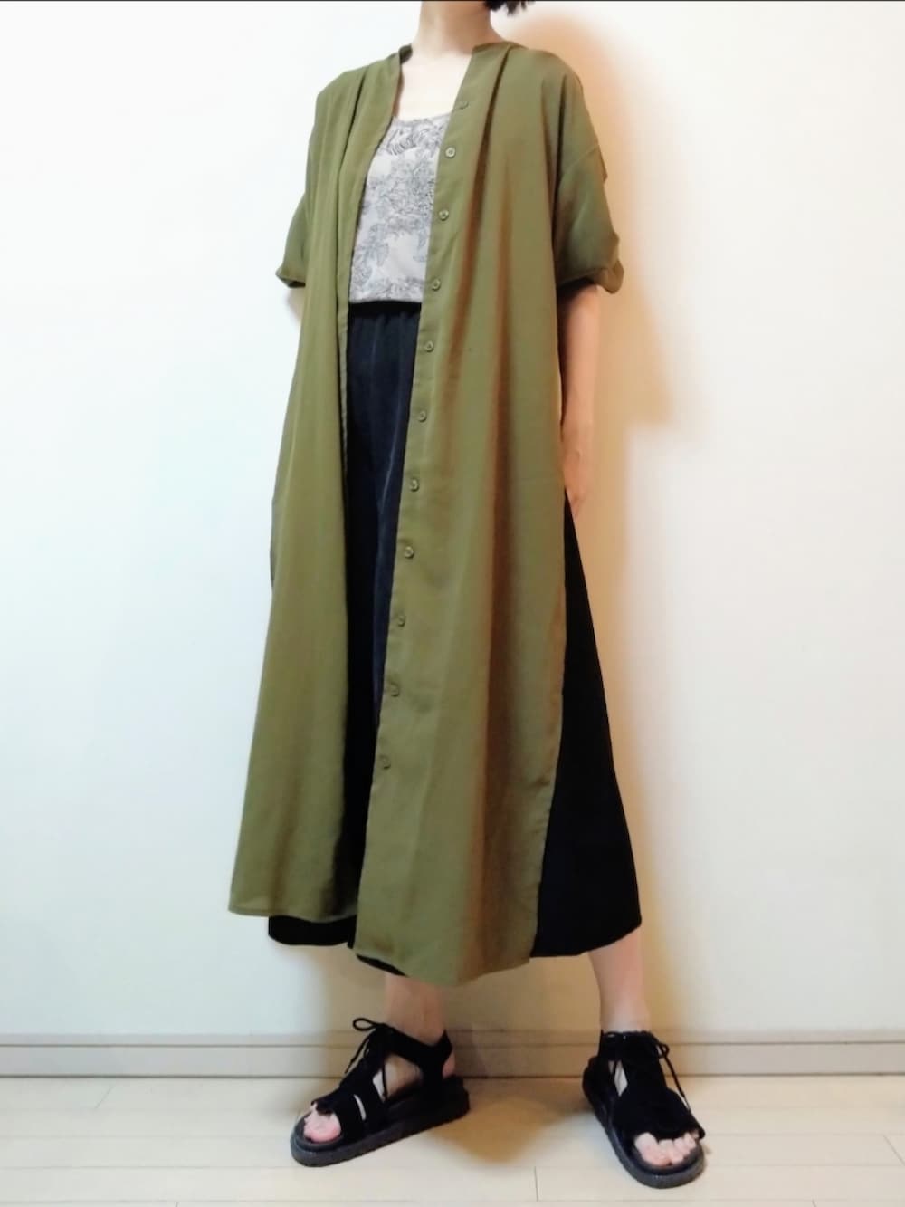 グリーン系のシャツワンピース、ベージュ系のタンクトップ、ブラック系のその他パンツを着用したレディースの夏コーディネートの2枚目の写真