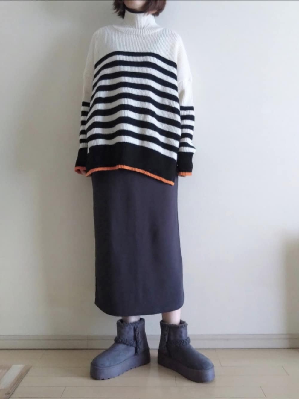 ブルー系のデニムジャケット、ホワイト系のニット/セーター、グレー系のスカートを着用したレディースの冬コーディネートの2枚目の写真