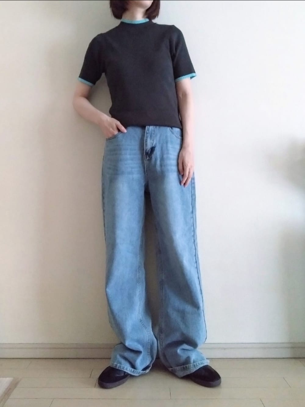 ブラック系のニット/セーター、ブルー系のデニムパンツ、ブラック系のスニーカーを着用したレディースの夏コーディネートの2枚目の写真