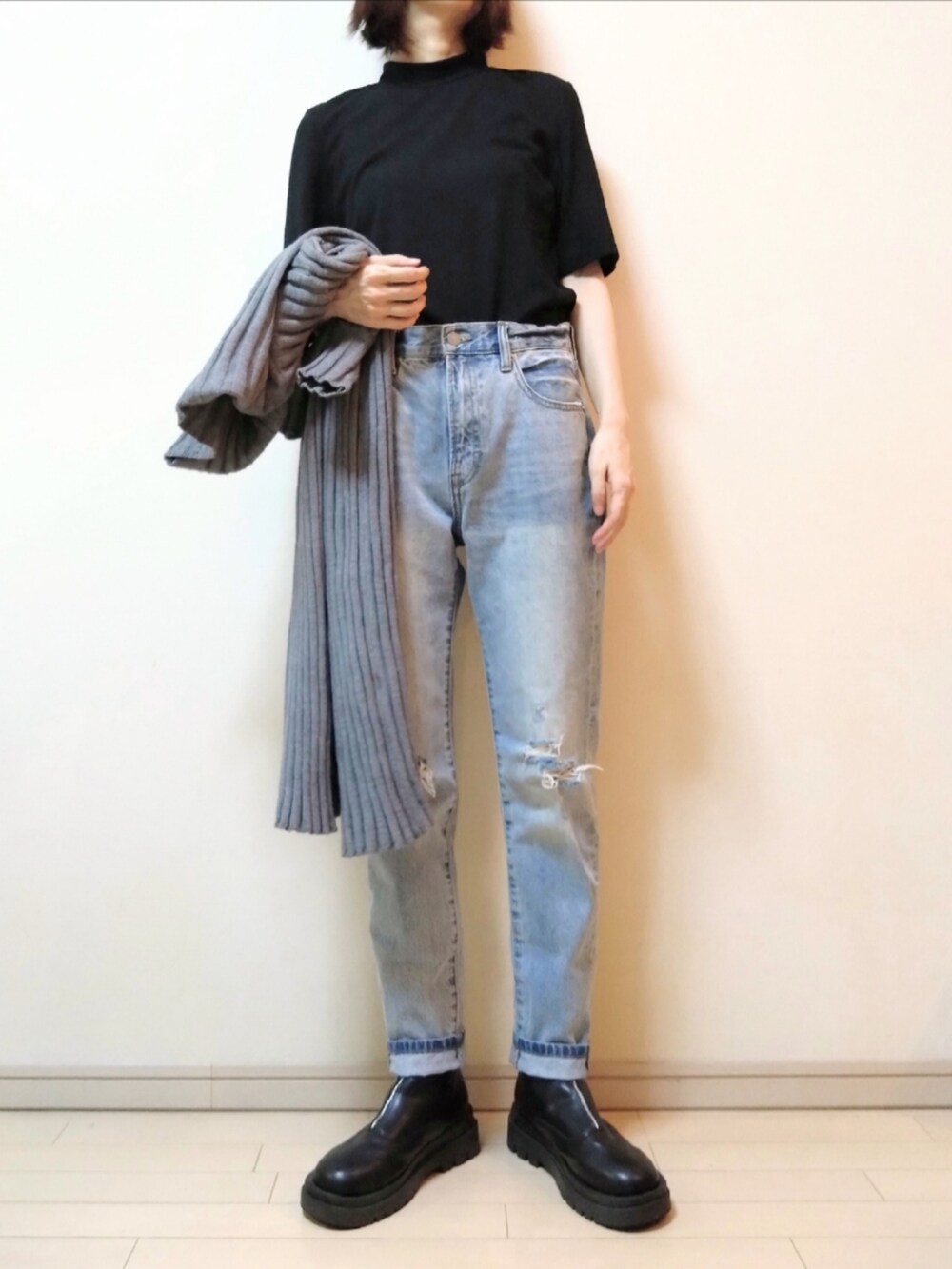 ブルー系のデニムパンツ、グレー系のカーディガン/ボレロ、ブラック系のTシャツ/カットソーを着用したレディースの秋コーディネートの2枚目の写真