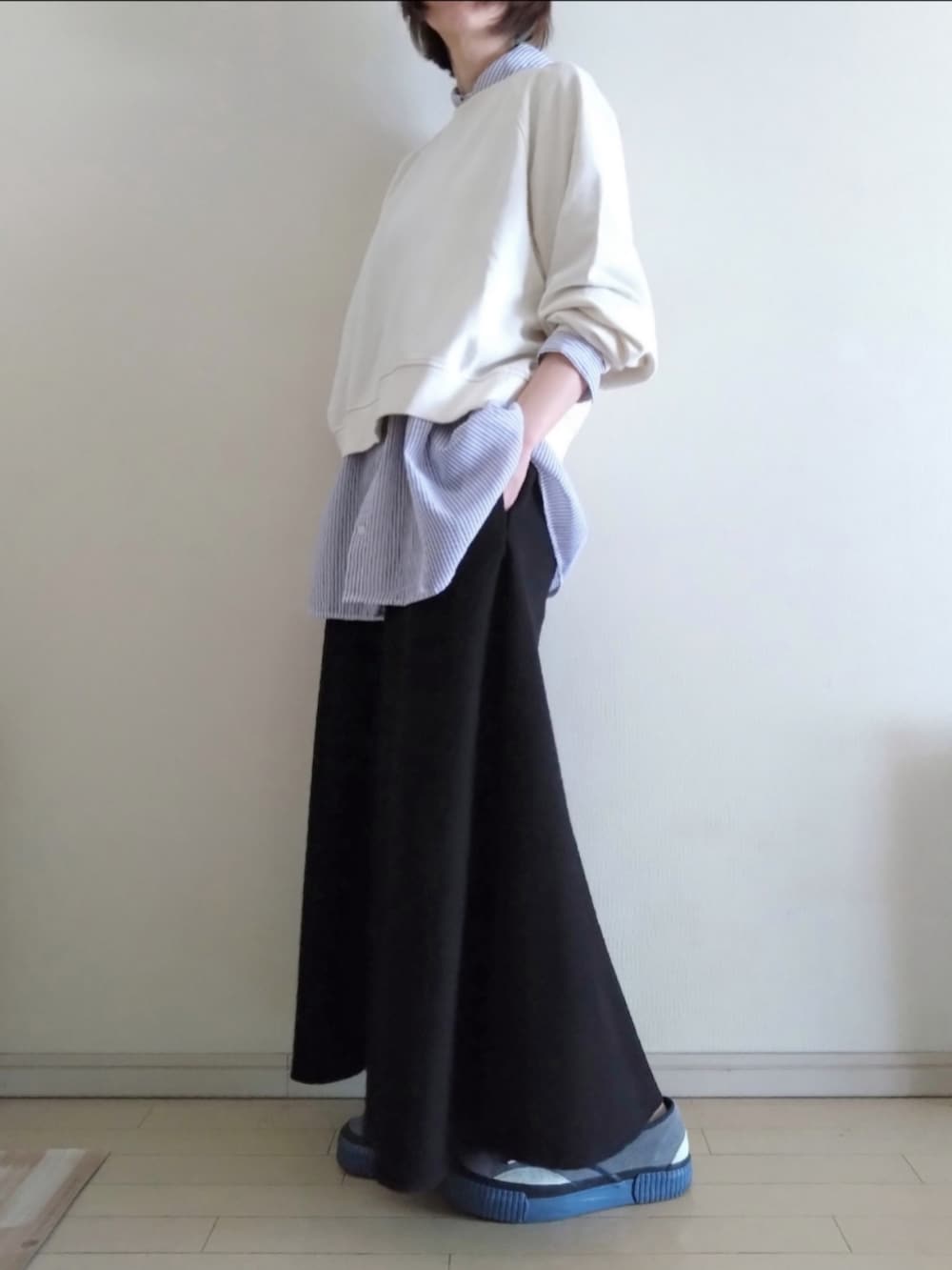 ホワイト系のスウェット、ブルー系のシャツ/ブラウス、ブラック系のスカートを着用したレディースの春コーディネートの2枚目の写真