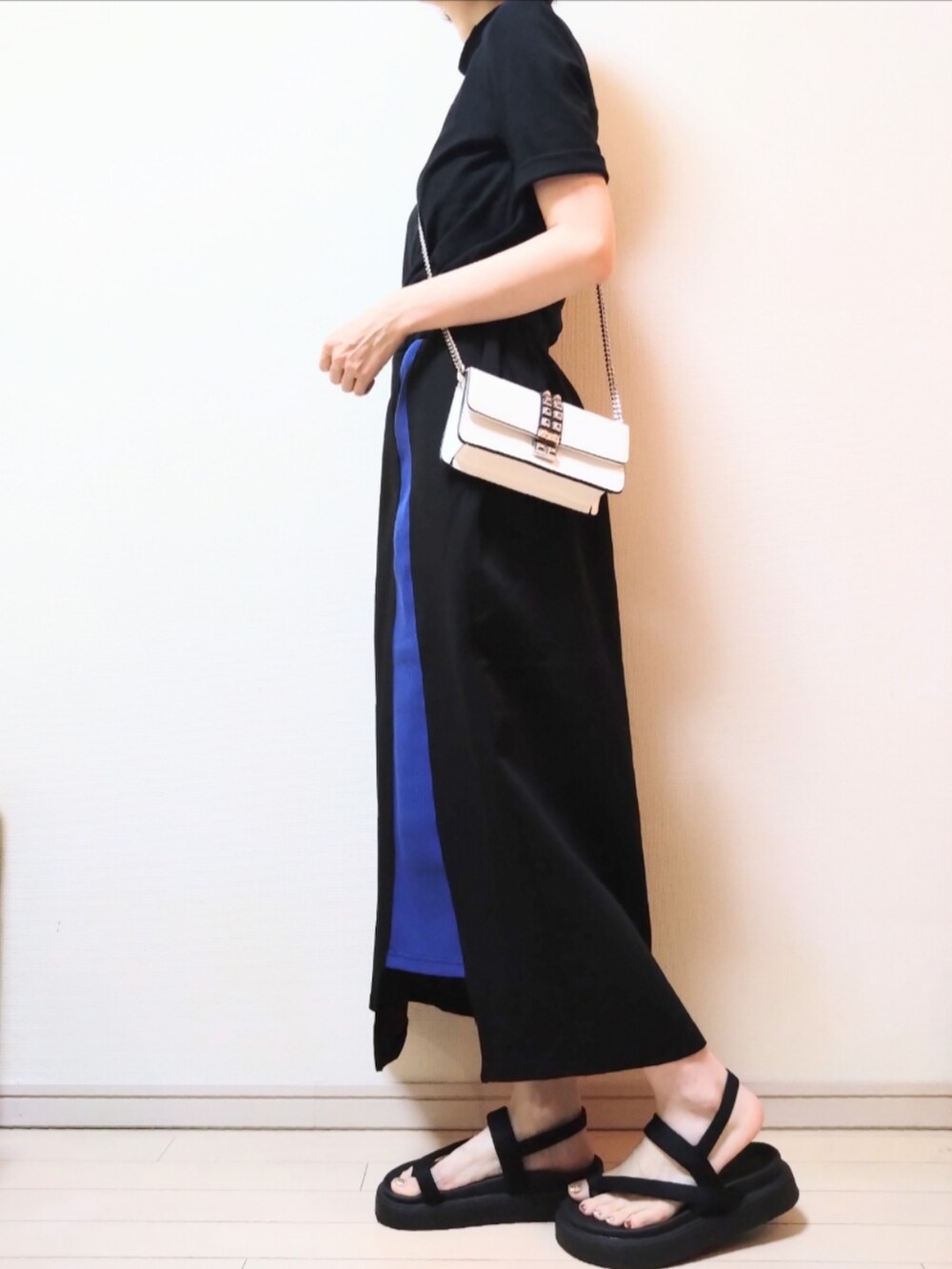 ブラック系のTシャツ/カットソー、ホワイト系のショルダーバッグ、ブラック系のスカートを着用したレディースの夏コーディネートの2枚目の写真