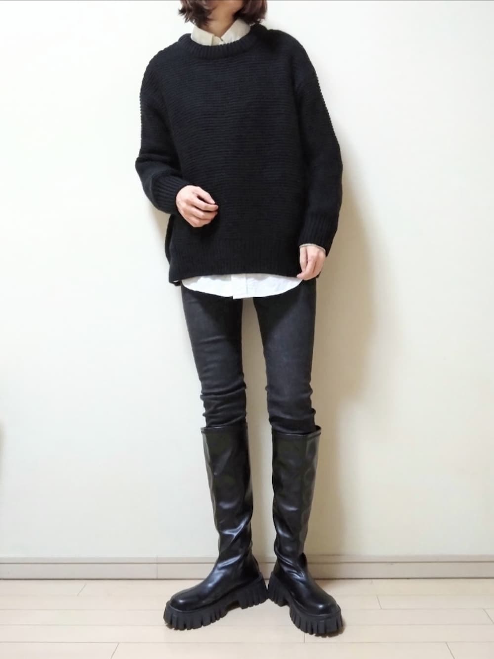 ブラック系のステンカラーコート、ブラック系のニット/セーター、ホワイト系のシャツ/ブラウスを着用したレディースの冬コーディネートの2枚目の写真