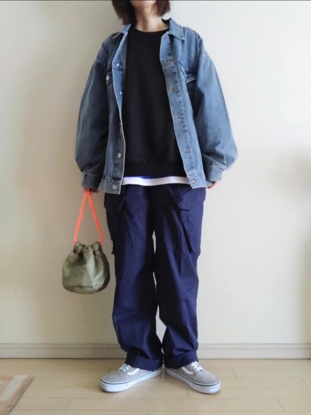 ブルー系のデニムジャケット、ブラック系のスウェット、ブルー系のTシャツ/カットソーを着用したレディースの春コーディネートの2枚目の写真