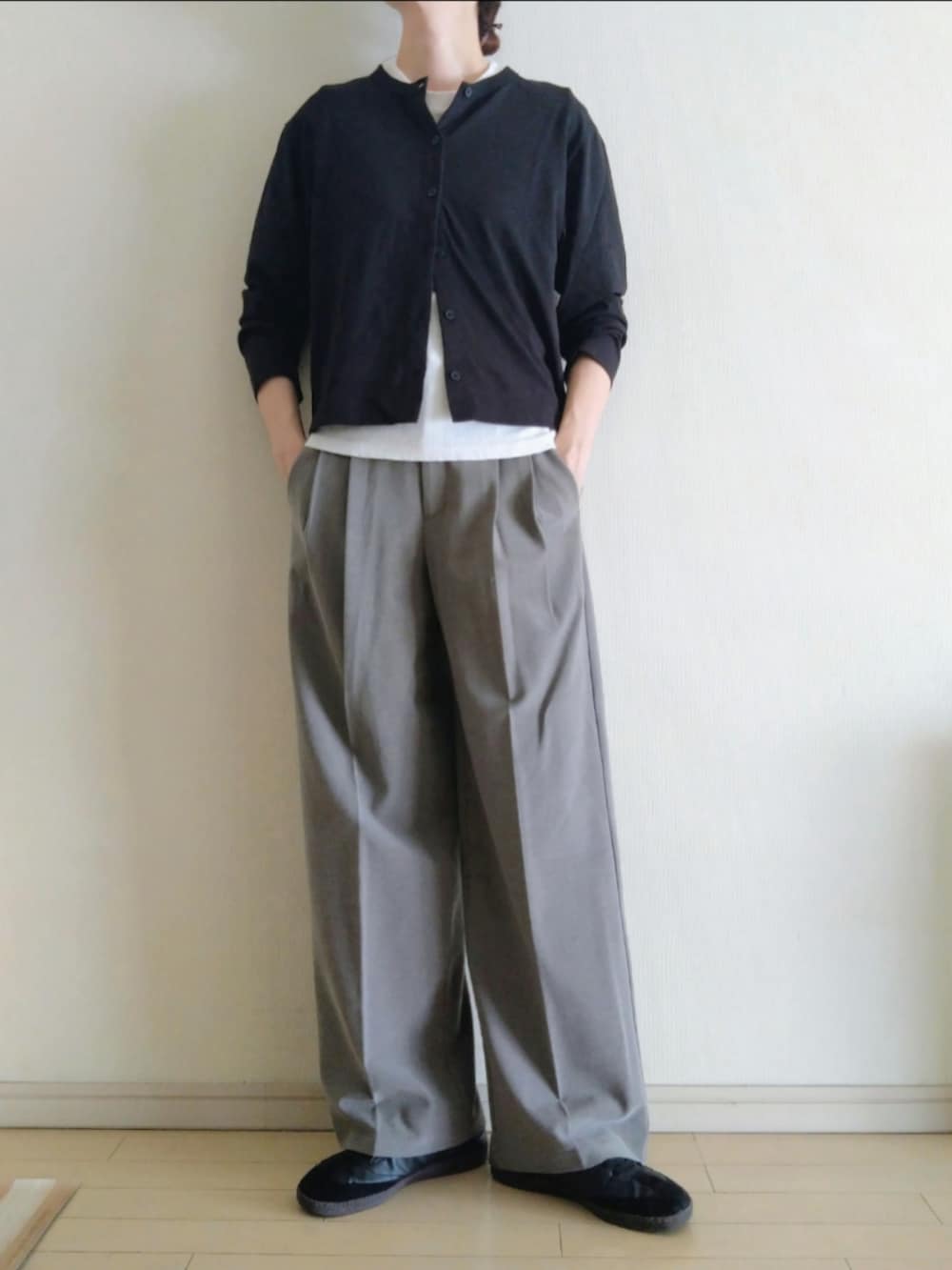 ブラック系のカーディガン/ボレロ、ホワイト系のTシャツ/カットソー、ブラウン系のスラックスを着用したレディースの秋コーディネートの2枚目の写真