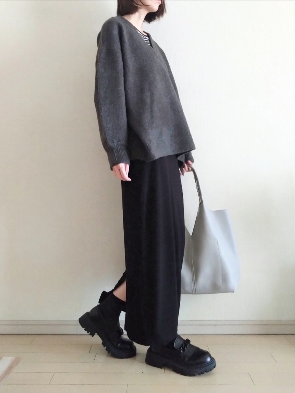 グレー系のニット/セーター、その他のTシャツ/カットソー、ブラック系のスカートを着用したレディースの春コーディネートの2枚目の写真